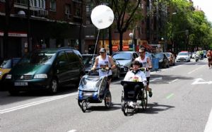 Pedro y su amigo Manuel, con Carlos Espada en la silla de ruedas durante una carrera