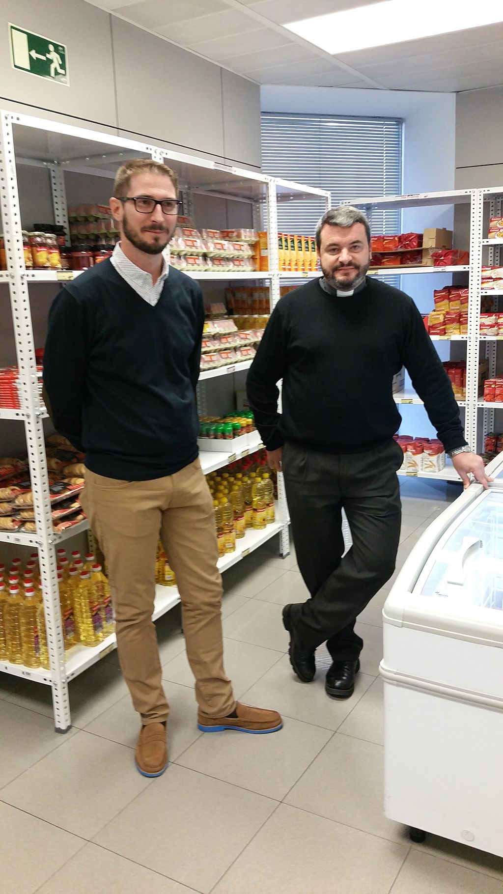 Dimás Noguera (izquierda) y Enrique González (derecha), de Cáritas Madrid, en el economato "Cáritas Multiplica"